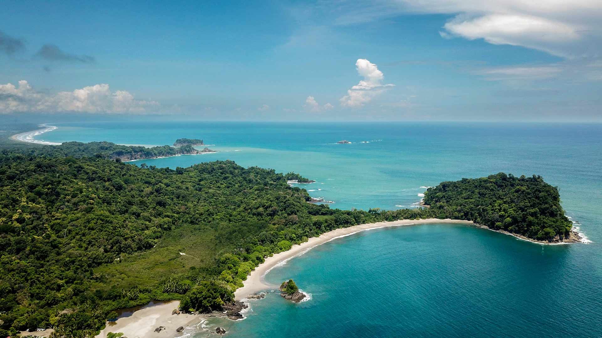 Aerial view of Manuel Antonio National Park rainforest meeting Pacific Ocean coves